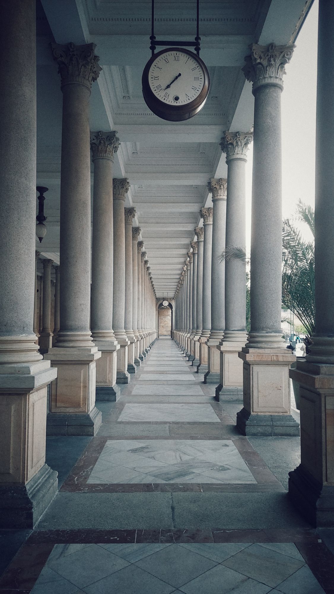 An empty pillar walk. And a clock.