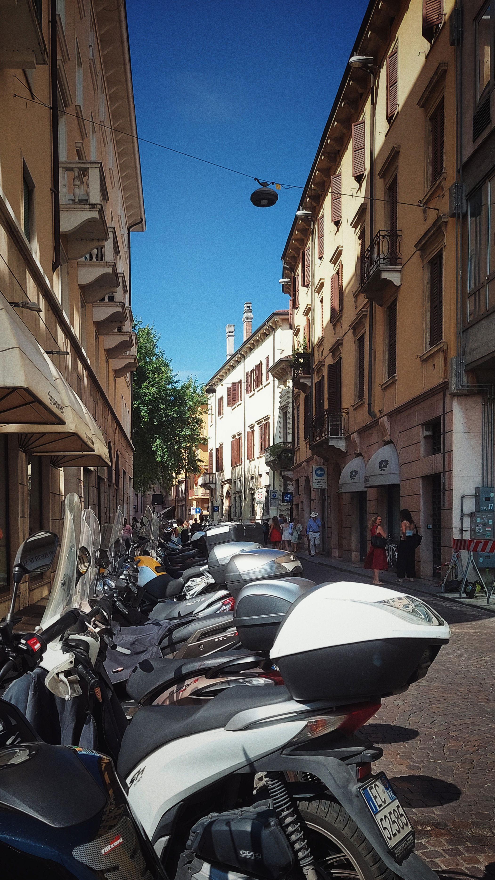 Italian street scene. A bunch of Vespas parked in front of an old building.