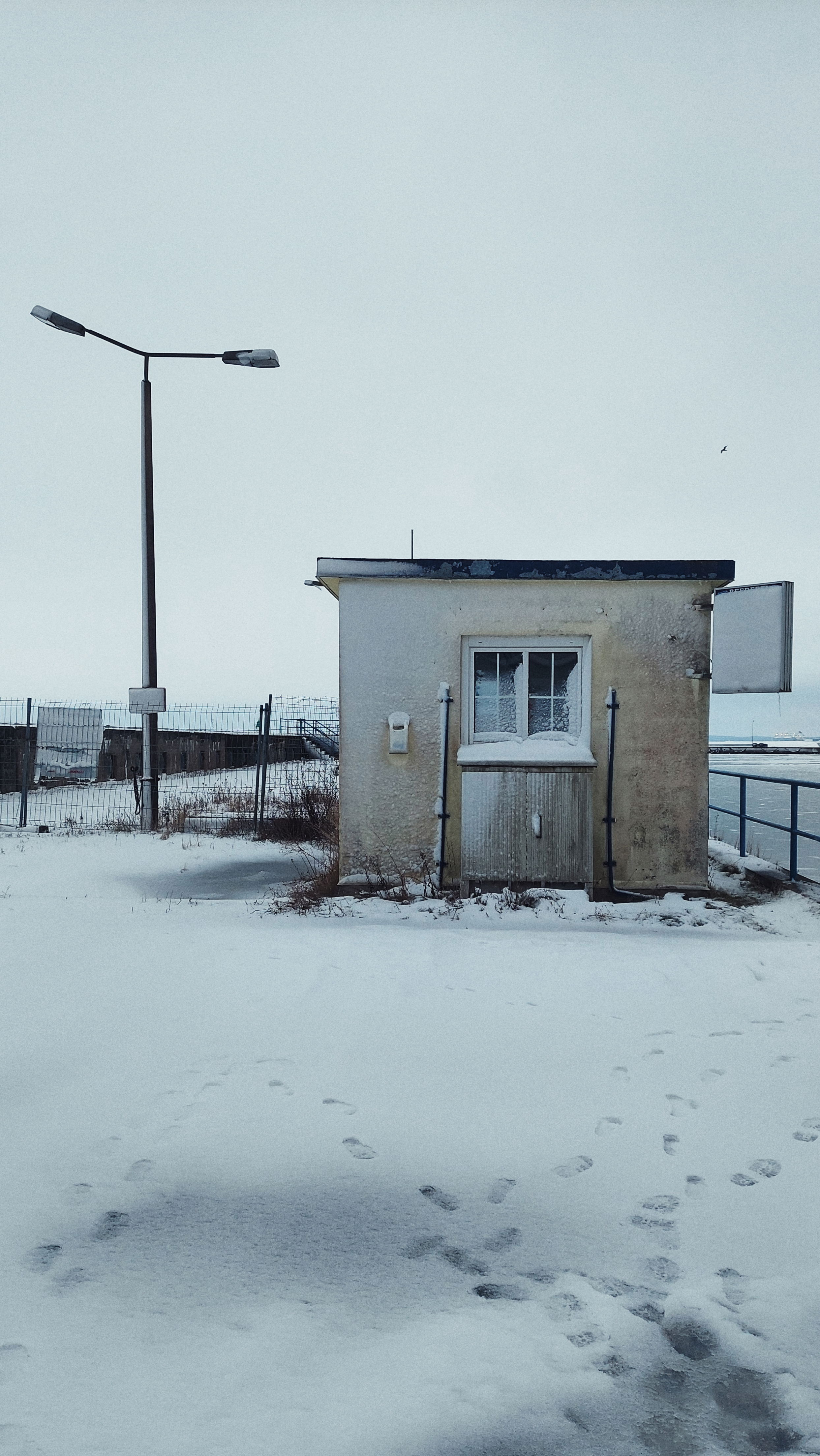 An old house in the city port area. Closed down, windows covered with snow.