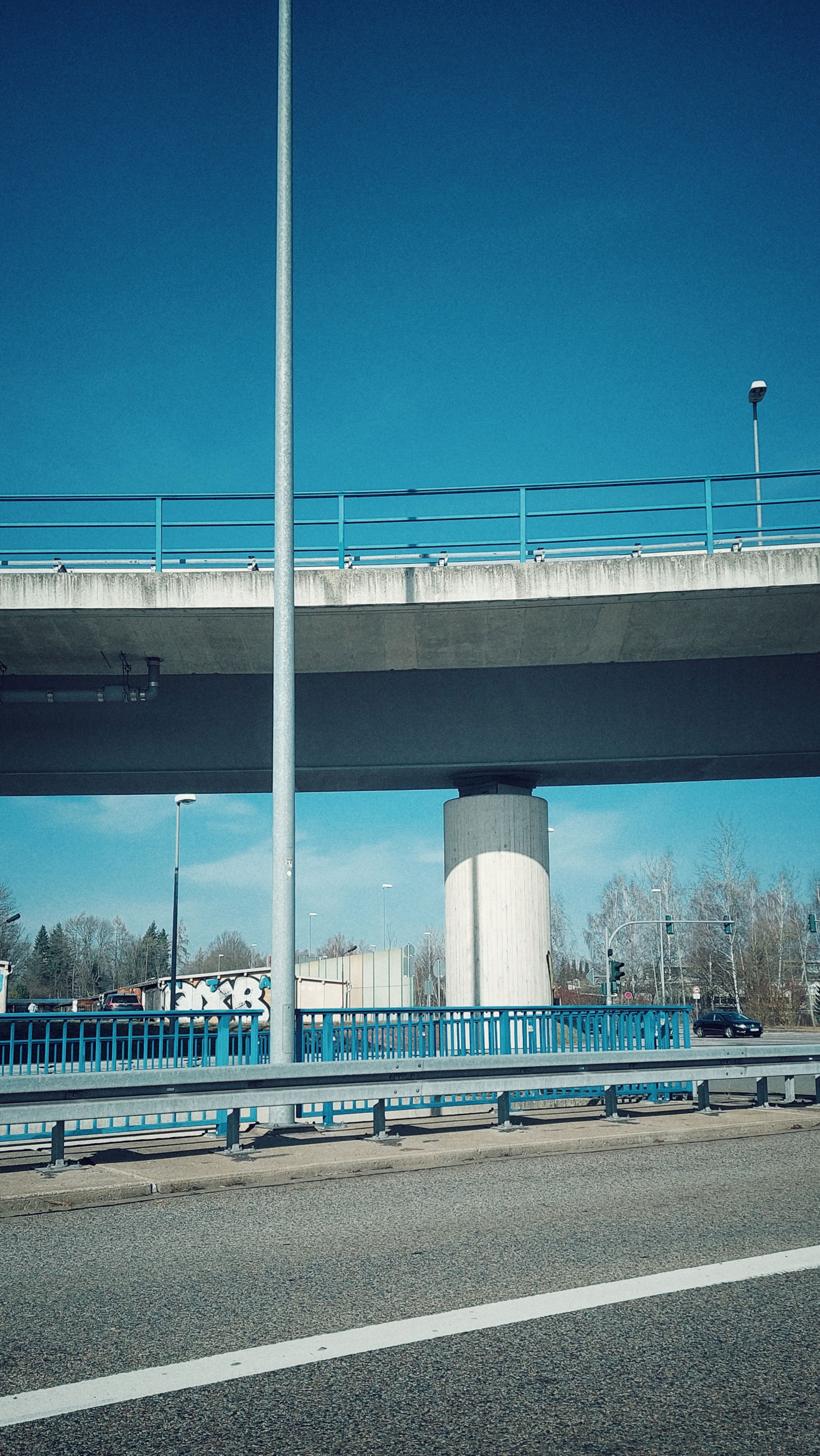 A highway scene. Empty road, and a road bridge above.