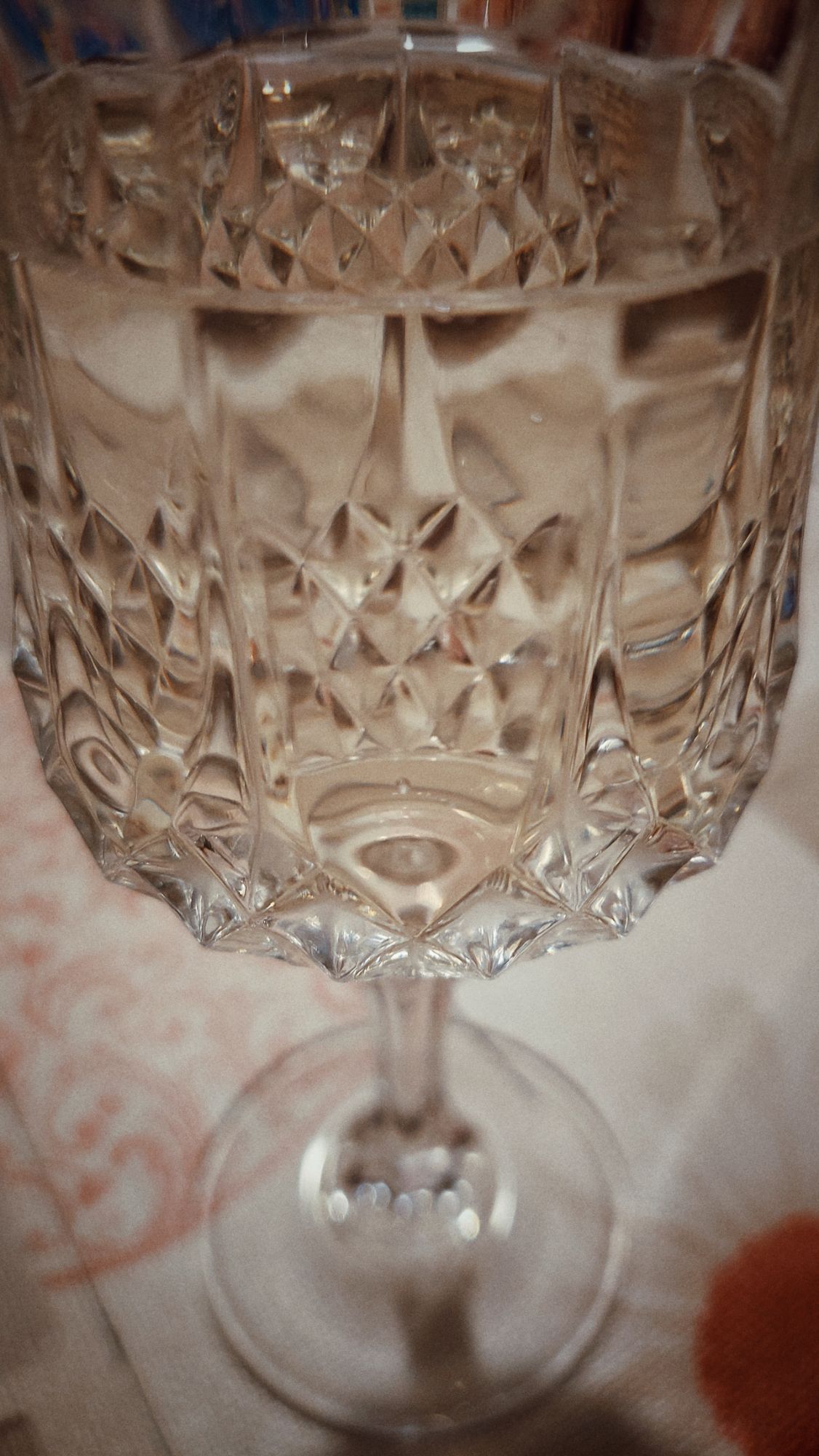 A crystal glass containing white wine. 