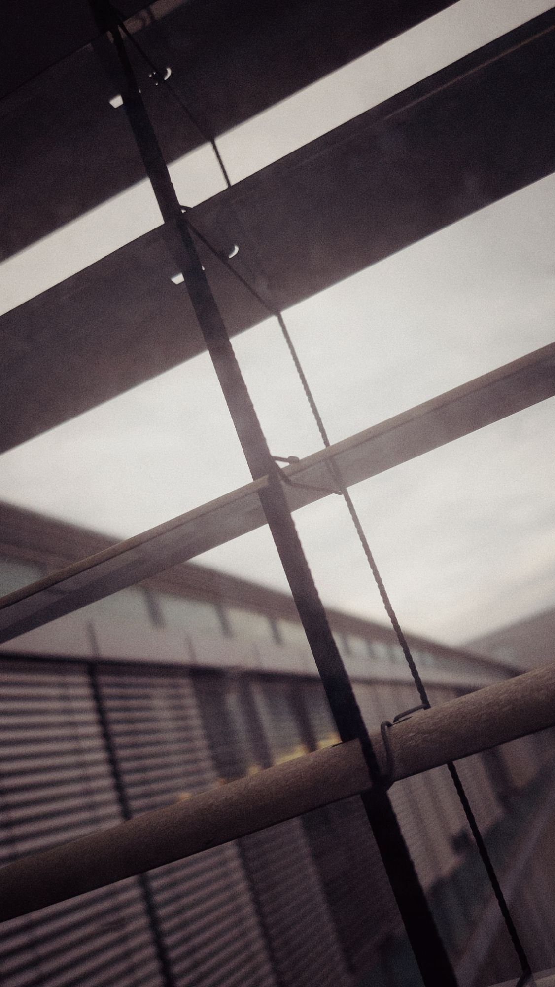 Afternoon sun through grey, behind windowblinds in an office building.