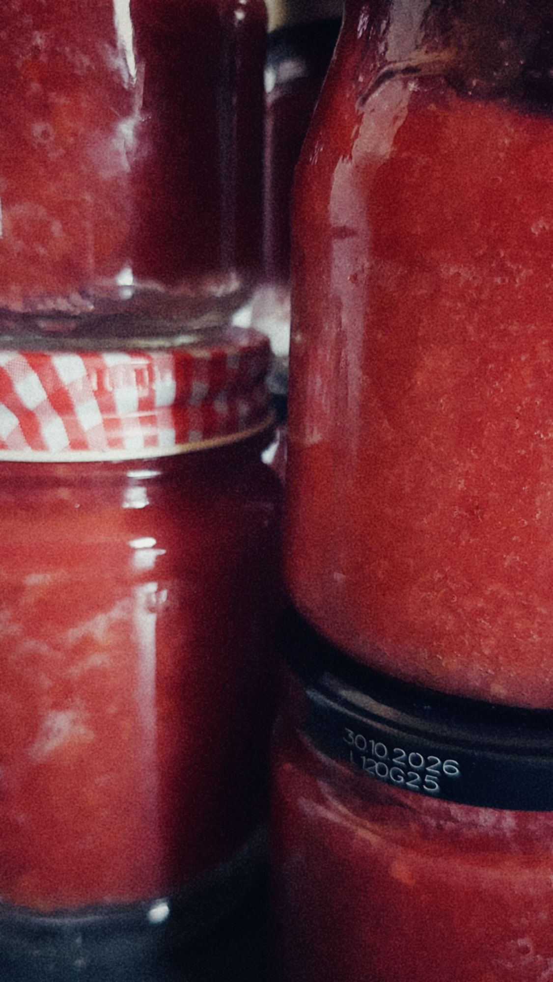 Jars containing cherry jam. Closeup.