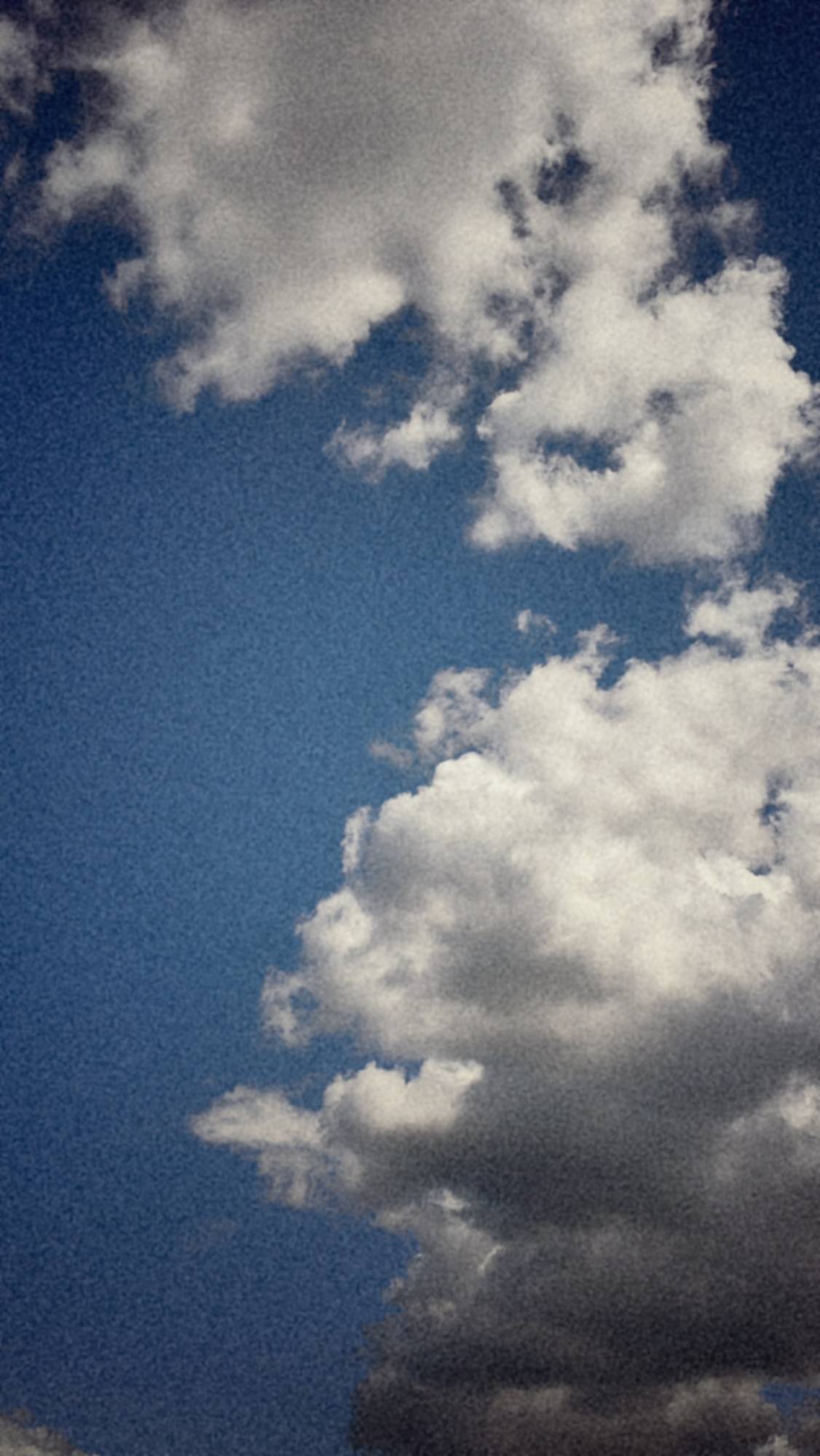 White and grey clouds on a mostly blue sky.