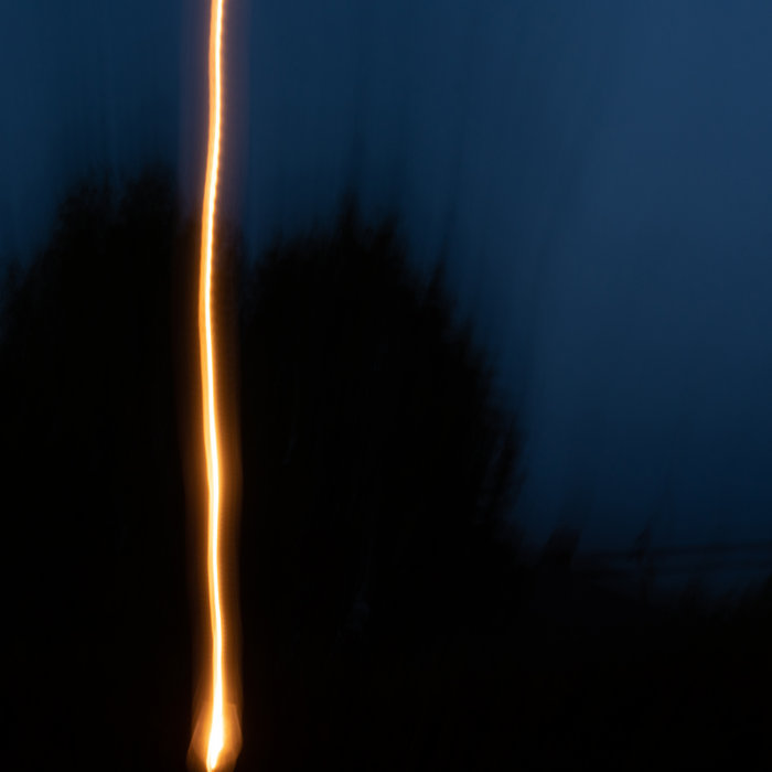 loscil Umbel cover artwork. A blurred photo featuring what seems dark blue sky, dark trees and a light trail of some lantern.