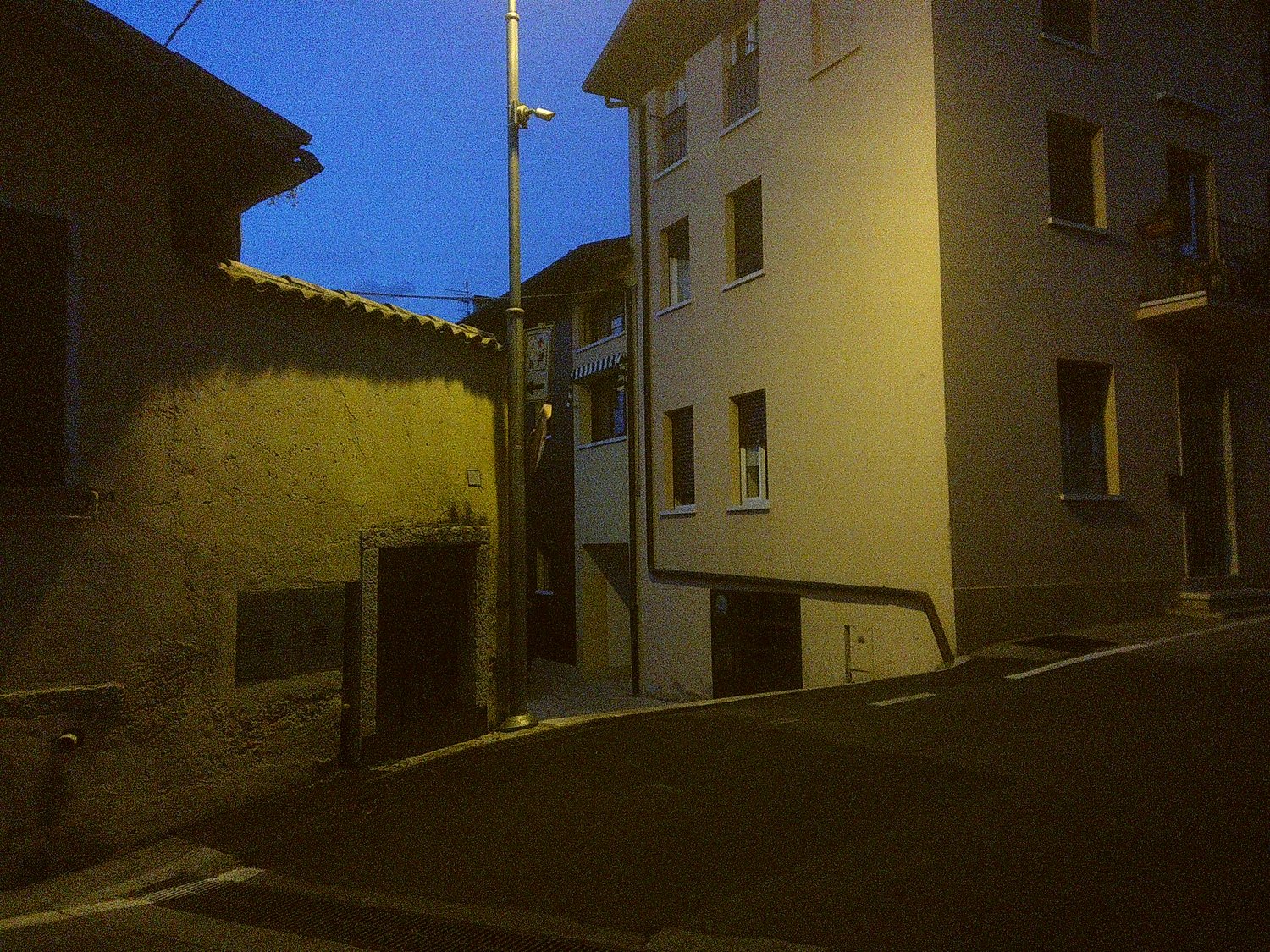 An Italian city at dusk. A dimly lit street corner.