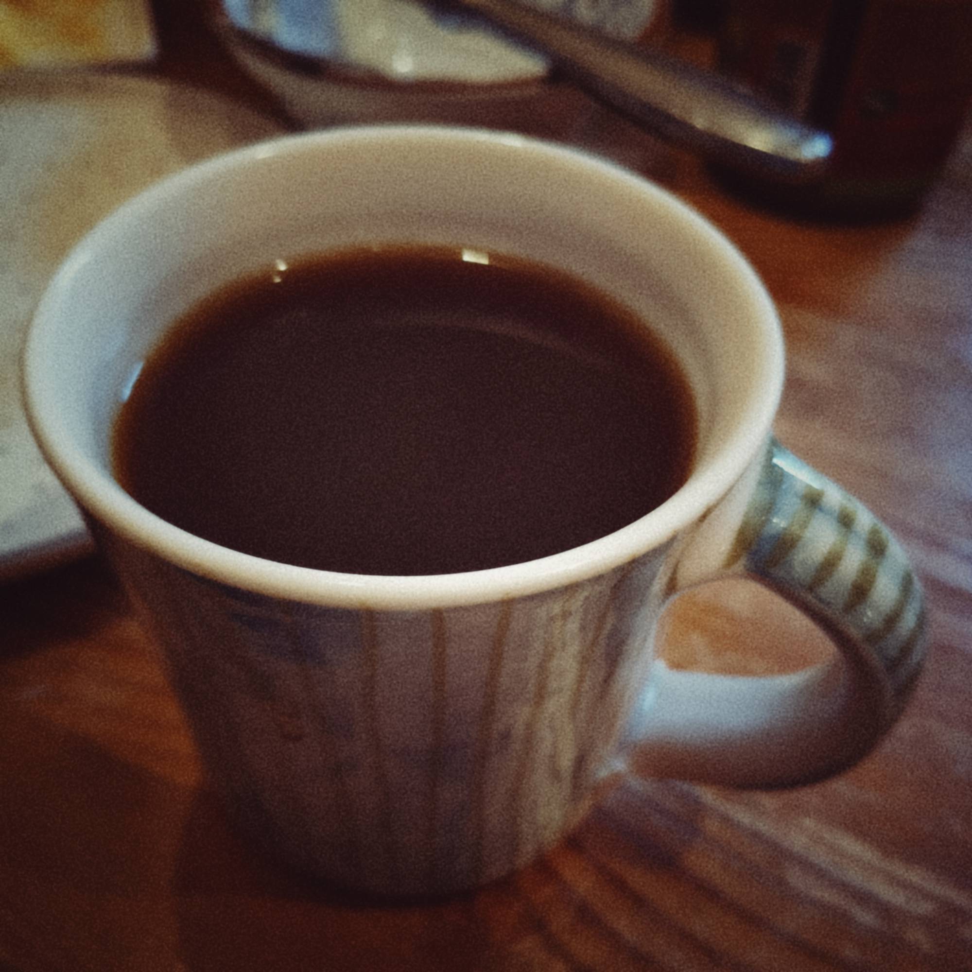 A mug of black coffee on a breakfast table.